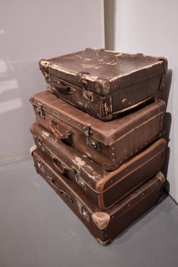 İçerde sembolik seyahat ve nostalji olarak kullanılan eski moda bavul yığını.