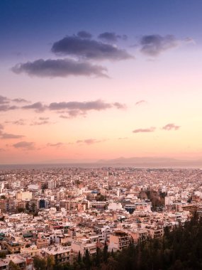 Yoğun ufuk çizgisi, pastel gökyüzü ve seyahat veya kentsel tasarım için kopyalama alanı bulunan Atina ve Yunanistan 'ın dikey gün batımı kentsel manzarası.