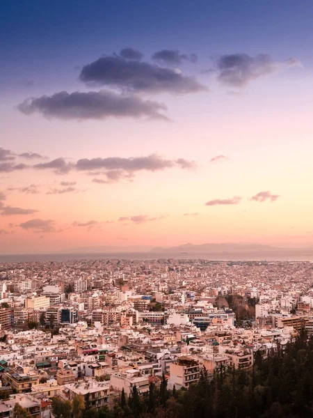 Yoğun ufuk çizgisi, pastel gökyüzü ve seyahat veya kentsel tasarım için kopyalama alanı bulunan Atina ve Yunanistan 'ın dikey gün batımı kentsel manzarası.