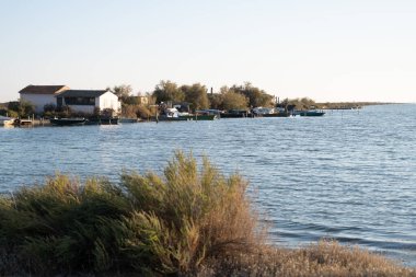 Önünde bir kapı olan büyük bir kemer yolu. Kemer yolu taştan yapılmış ve kapı metalden yapılmış. Gökyüzü açık ve mavi. Villeneuve-les-Maguelone 'da, Fransa' nın güneyinde Herault Bölümü 'nde bir kasaba.