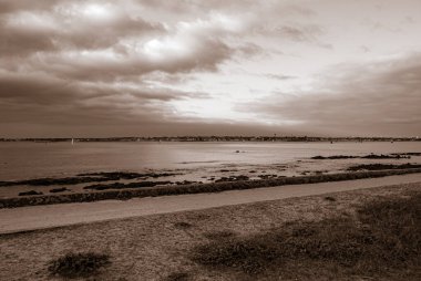 Arka planda bulutlu bir gökyüzü olan bir plaj. Gökyüzü bulutlu ve plaj boş. Gavres Yarımadası, Britanya, Fransa