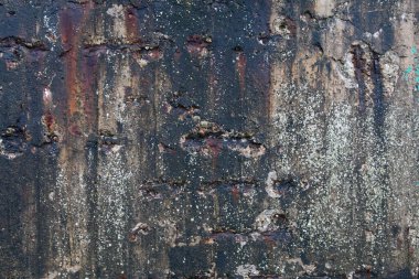 Yıpranmış betona yakın çekim, açıkta kalan toplam beton, pas lekeleri ve soyulan boya. Yaşlanma ve madde bozulmasını gösteren detaylı doku..