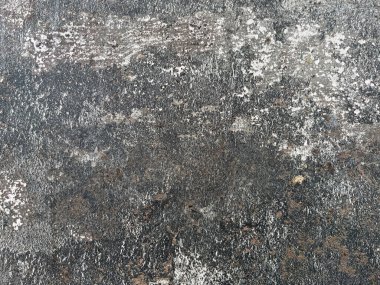 Eskimiş, desenli, koyu gri tonlar ve beyaz yamalarla kaplanmış bir yüzeye yakın çekim. Yaşlanma, erozyon ve grunge tarzı bir arka plan için doğal aşınma izleri var..