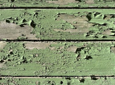 Yıpranmış ahşap tahtaların yakın çekimi altında yeşil boya soyuluyor ve alttaki eski ahşabı ortaya çıkarıyor. Sorunlu doku kırsal veya eski arkaplanlar için idealdir.