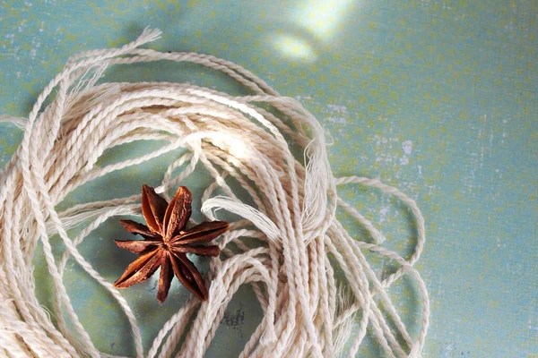 Turkuaz arka planda yıldız anasonu. Bej iplikler ve baharatlar. Tasarım için arkaplan, doku. 