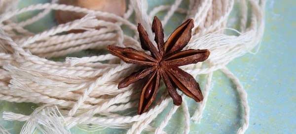 Turkuaz arka planda yıldız anasonu. Bej iplikler ve baharatlar. Tasarım için arkaplan, doku. 