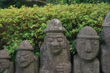 Dol Hareubang Taş Heykelleri, Jeju Adası, Kore 'nin sembolü, Yeşil Çalılara karşı yan yana durmak