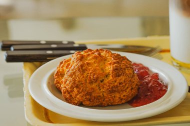 Çilek reçeli ve çatal ve bıçak setli taze pişmiş çöreğin yakın çekimi