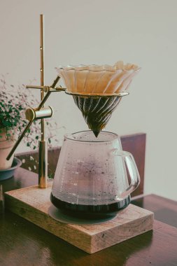 Elle damlatılan kahve cam sunucuya aktarılıyor