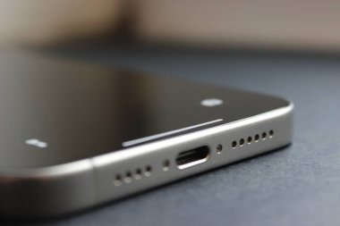 Modern akıllı telefonların detaylı makrosu USB-C portu ve koyu gri hoparlörlerde simetrik delikler.