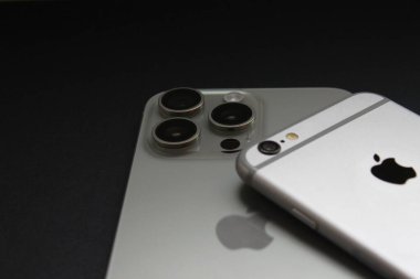 iPhone 6 'nın iPhone 15 Pro Max üzerindeki yakın görüntüsü, tek ve üçlü kameraları vurguluyor. Sadece editör kullanımı.