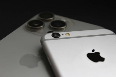 iPhone 6 'nın iPhone 15 Pro Max üzerindeki yakın görüntüsü, tek ve üçlü kameraları vurguluyor. Sadece editör kullanımı.