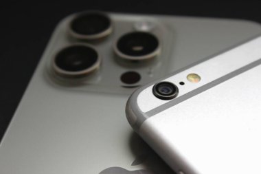 iPhone 6 'nın iPhone 15 Pro Max üzerindeki yakın görüntüsü, tek ve üçlü kameraları vurguluyor. Sadece editör kullanımı.