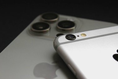 iPhone 6 'nın iPhone 15 Pro Max üzerindeki yakın görüntüsü, tek ve üçlü kameraları vurguluyor. Sadece editör kullanımı.