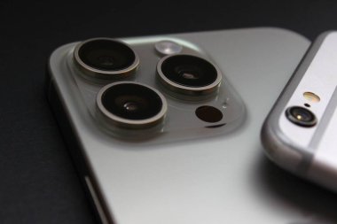 iPhone 6 'nın iPhone 15 Pro Max üzerindeki yakın görüntüsü, tek ve üçlü kameraları vurguluyor. Sadece editör kullanımı.