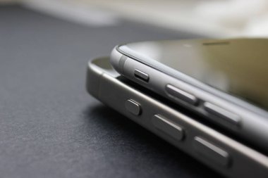 Yüksek sesli ve sessiz tuşlara odaklı yığılmış akıllı telefonlar, nötr stüdyo ışıklandırması - genel aygıt detayı.