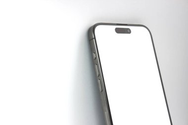 Yan düğmeleri ve beyaz ekranı gösteren şık bir akıllı telefonun yakın çekim açısı. UI sunumları, donanım reklamları veya teknik blog başlıkları için mükemmel.