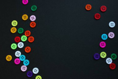 Çoklu renkli dikiş düğmeleri siyah desenli kağıt üzerinde geniş bir kopya alanı çerçeveler - metin veya markalaşma için idealdir.