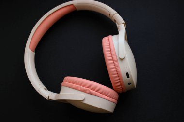 Mat siyaha asgari düzeyde kablosuz kulaklık. Tasarım veya metin için cömert negatif alanı olan çağdaş ürün çekimi.