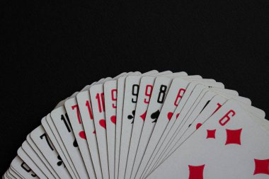 Rakamları ve takımları gösteren oyun kartlarının makro görüntüsü. Gerçekçi ve dokunsal bir görünüm için görünen desenli kağıt kenarları.