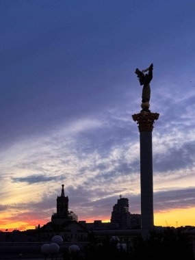 Meydan Nezalezhnosti 'deki Bağımsızlık Anıtı Ukrayna' nın başkenti Kyiv 'de canlı bir günbatımı ve şehir siluetine karşı yükseliyor.