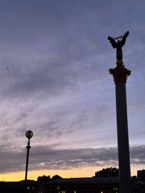 Meydan Nezalezhnosti 'deki Bağımsızlık Anıtı Ukrayna' nın başkenti Kyiv 'de canlı bir günbatımı ve şehir siluetine karşı yükseliyor.