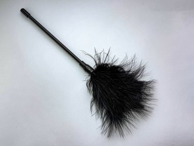 Siyah tüy gıdıklayıcı beyaz arka planda izole edildi, ince saplı ve yumuşak dumanlı oyuncu duyusal aksesuar.