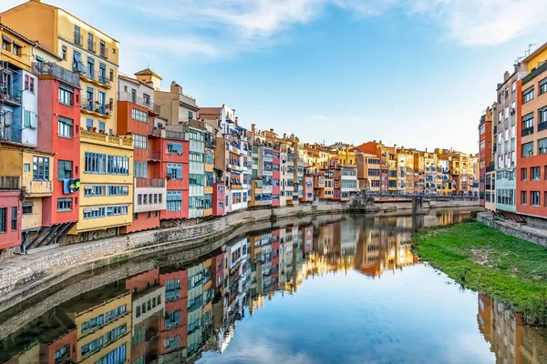 İspanya 'nın Girona kentindeki Onyar Nehri boyunca renkli evler, canlı yüzleri durgun suya mükemmel bir şekilde yansıyor. İkonik çok renkli binalarda nehir kıyısında balkonları ve pencereleri olan geleneksel Katalan mimarisi sergileniyor.