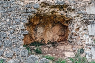 Girona 'daki Montjuic kalesinin duvarlarına oyulmuş antik taş oyuk yıpranmış kaya yüzeyleri ve kısmen çürümüş İspanya' yı gösteriyor. Bu tarihi askeri mevkinin temelinde sürekli büyüyen küçük bitkiler var.