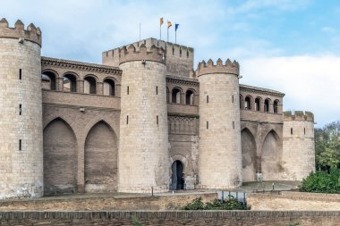 Aljaferia Sarayı 'nın tarihi cephesinde Zaragoza' daki karmaşık Mudejar kemerleri ve yuvarlak taş kuleler görülüyor. İspanya 'daki İslami mimarinin en önemli örneği yumuşak bir gün ışığı altında