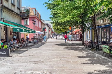 Cetinye 'deki Njegoseva caddesinde açık kafelerde ve hediyelik eşya dükkanlarında dinlenen turistler var. Bu yaya geçidi tarihi Kraliyet Sarayı 'na çıkıyor. Cetinje, Karadağ - 20 Haziran 2021