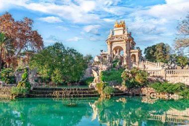 Güneşli bir sonbahar gününde İspanya 'nın Barcelona kentindeki Ciutadella Park' ında Cascade Fountain veya Waterfall. Mavi bulutlu gökyüzüne karşı ünlü mimari dönüm noktası
