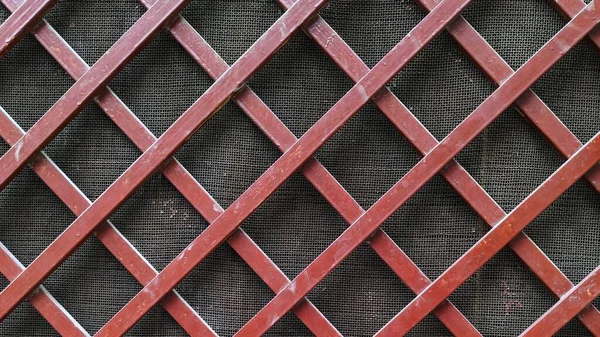 Koyu ağların üzerinde kırmızı ahşap kafes