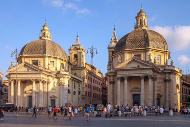 Roma 'daki Piazza del Popolo' daki Montesanto 'da Santa Maria dei Miracoli ve Santa Maria ikiz kiliselerinde, turistler ünlü İtalyan meydanını, güneşli günü ve klasik kubbeleri keşfediyorlar..