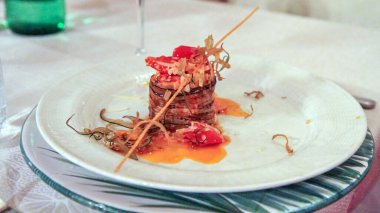 Domates, otlar ve peynirli İtalyan patlıcan aperatifinin sanatsal sunumu. Rafine kaplamalı ve Akdeniz aromalı güzel bir restoran yemeği..