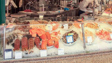 Bir market tezgahında buzda somon, ıstakoz kuyruğu, karides ve kabuklu deniz ürünleri sergileniyor. Gıda perakendecisi, gastronomi ve sağlıklı beslenme konsepti.