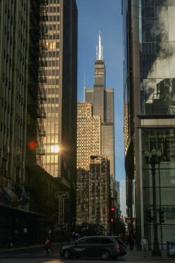 28 Eylül 2013. Chicago, Illinois, ABD. Willis Kulesi 'nin sokak seviyesindeki manzarası Chicago şehir merkezindeki gökdelenler arasında yükseliyor ve arka planda güneş parlıyor..