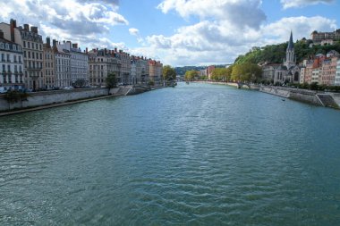 Tarihi binalar, kilise kulesi, köprüler ve dramatik bulutlarla Lyon 'daki Saone Nehri' nin geniş manzarası. Avrupa seyahatleri ve şehir manzarası.