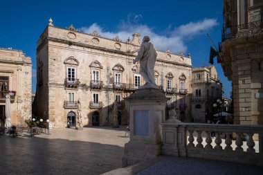 Kilise tarihi binalarla çevrili manzaralı bir meydanda dimdik ayakta duruyor..