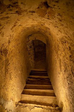 Merdivenler, loş bir İtalyan kilisesinin içine açılıyor..