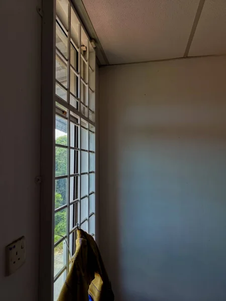 Bu resim, metal güvenlik ızgaralarıyla donatılmış bir pencerenin kapalı bir görünümünü gösterir.