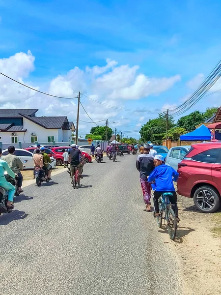 Terengganu. 5 Ağustos 2025. Görüntü, Cuma namazından hemen sonra Malezya 'daki bir cami veya yerleşim alanının dışında insanların motosiklet ve arabalarla dolaşmaya başladığı ve trafiğin tıkanmasına yol açtığı sahneyi gösteriyor..