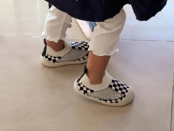 Bu bir çift siyah beyaz kareli bebek ilk yürüyüş ayakkabısı..