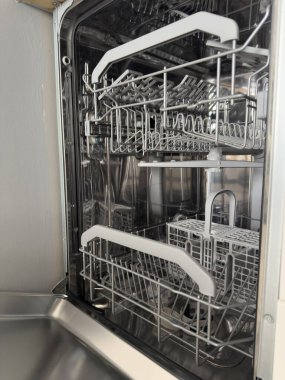 Modern mutfak ortamında temiz metal rafları olan boş bulaşık makinesini aç. Ev Temizliği Rutini. Yüksek kalite fotoğraf.