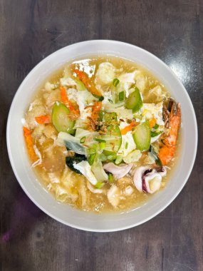 Bir kase deniz mahsullü şehriye çorbası, karides, kalamar, sebze ve sarımsak ve soğanla süslenmiş, et suyuyla kıtır kıtır erişte..