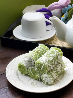 Yeşil silindirik Putu Bambu kekleri pandan katılmış pirinç unundan yapılır ve içi palmiye şekeri ile doldurulur, üstü de hindistan cevizi parçacıklarıyla kaplanır..