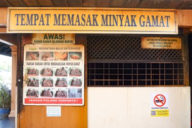 Kedah, Malezya, 3 Aralık 2025: Langkawi Adası 'ndaki geleneksel Gamat petrol işleme sahasının dışı, kültürel işaretler, güvenlik uyarıları ve miras temelli tıbbi uygulamalar sergileniyor.