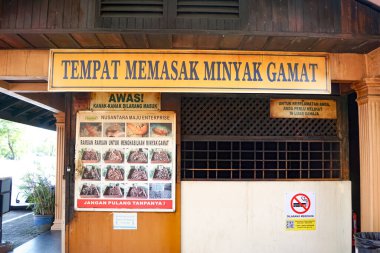 Kedah, Malezya, 3 Aralık 2025: Langkawi Adası 'ndaki geleneksel Gamat petrol işleme sahasının dışı, kültürel işaretler, güvenlik uyarıları ve miras temelli tıbbi uygulamalar sergileniyor.