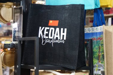 Kedah, Malezya, 5 Aralık 2025: Geleneksel Malezya pazarında sergilenen Kedah ve Alor Setar markalarının yer aldığı renkli çantalar ve hediyelikler.