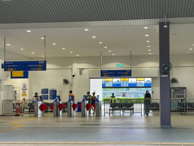 Johor, Malezya, 14 Ocak 2025: Otomatik turnikeler ve Kempas Baru istasyonundaki yön tabelası yolcuların giriş ve çıkışları.